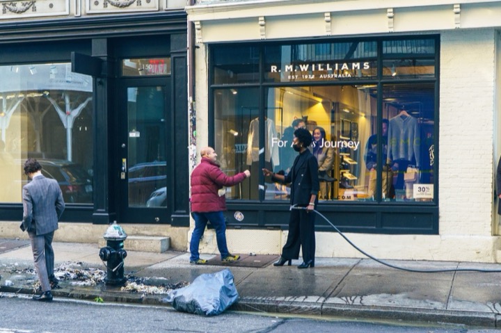 Workers hosing down the sidewalk outside a storefront