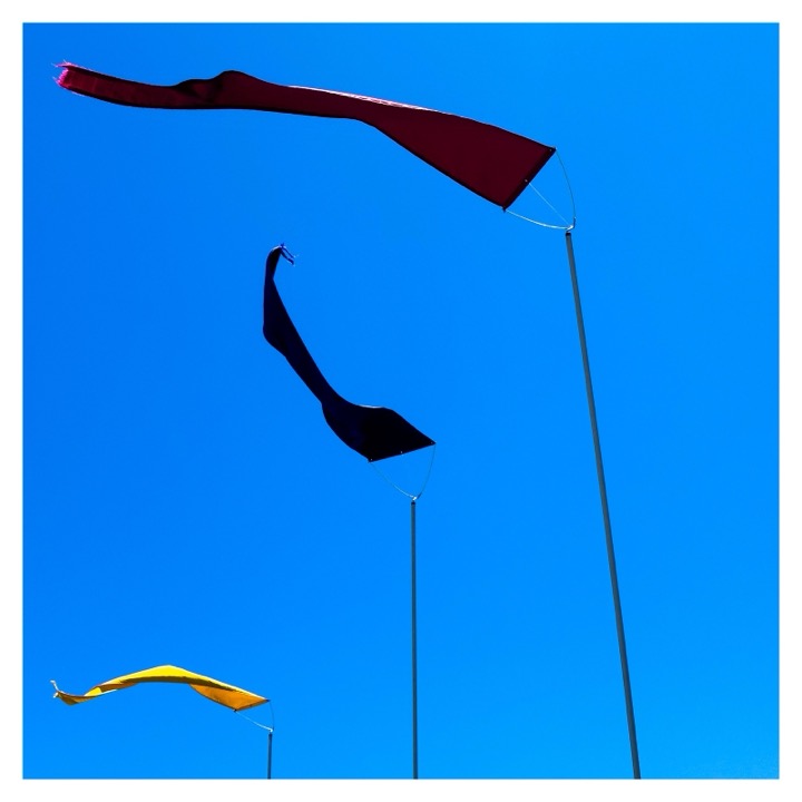Red and black banners flying against a bright blue sky