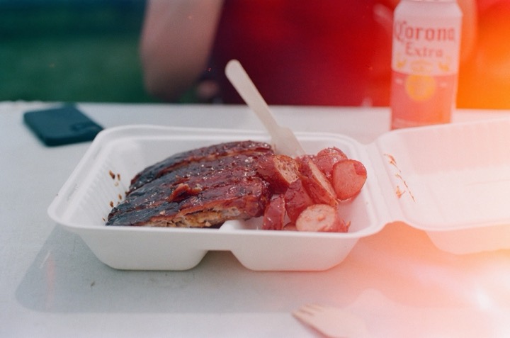 Grilled meat in a takeout container in warm evening light