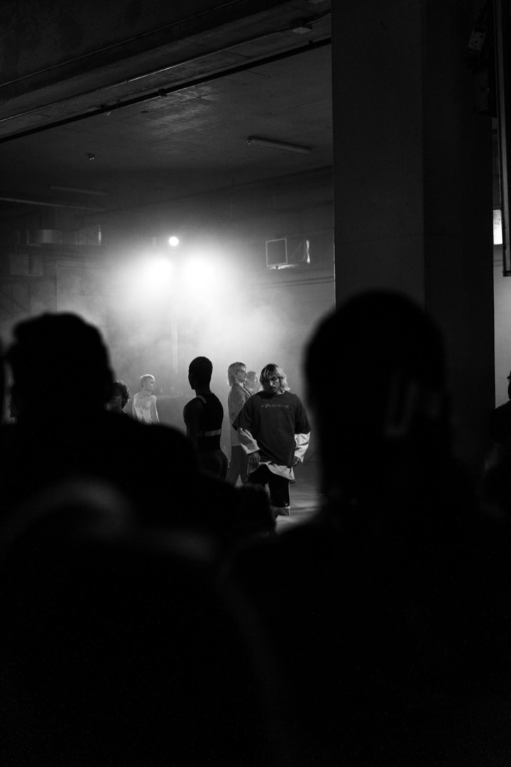 A silhouetted crowd at a dimly lit live show