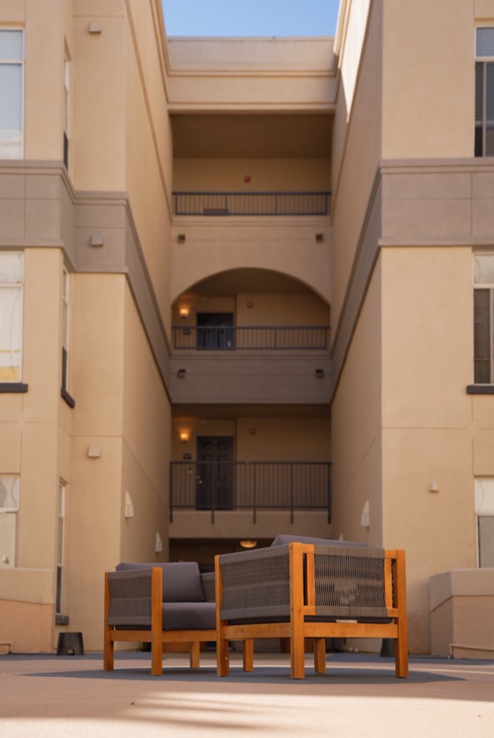 A sunlit apartment courtyard with outdoor chairs