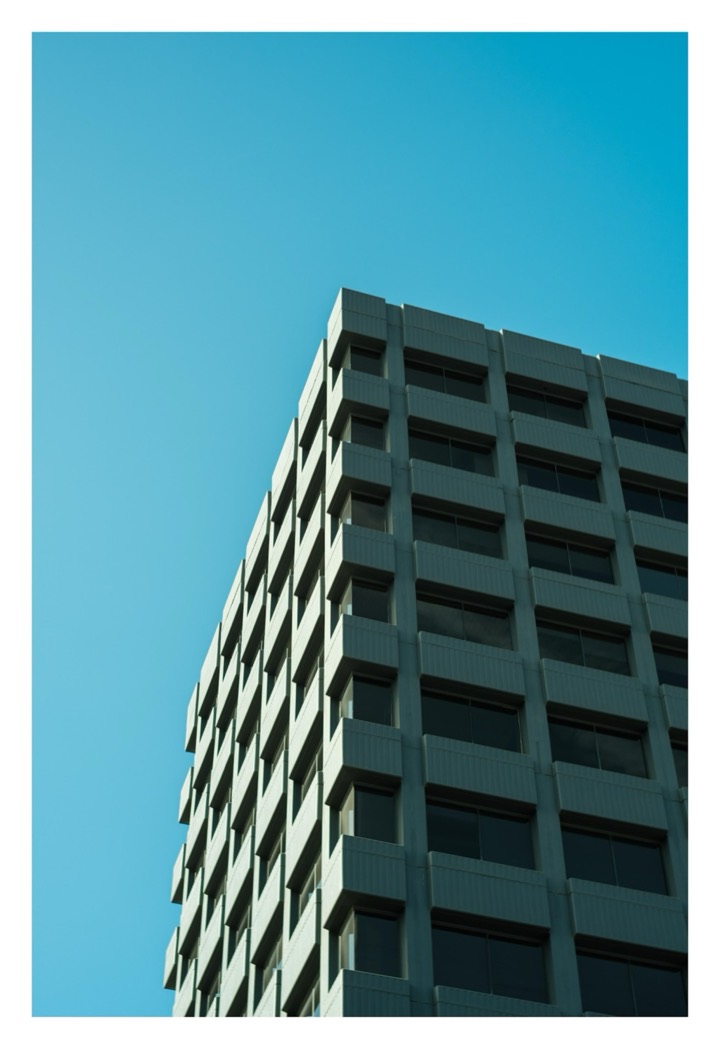 The corner of a building against a bright cyan sky